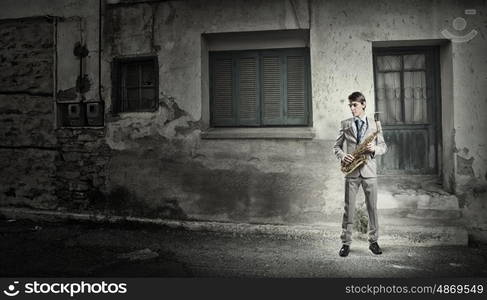 Handsome saxophonist. Young man in suit with saxophone in hands