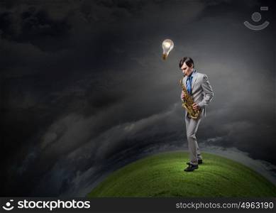 Handsome saxophonist. Young man playing saxophone and light bulbs coming out
