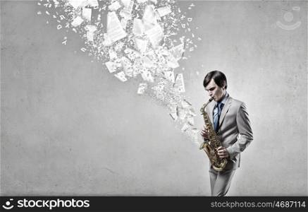 Handsome saxophonist. Young man playing saxophone and papers coming out