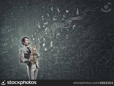 Handsome saxophonist. Young man playing saxophone and sketches at bacground