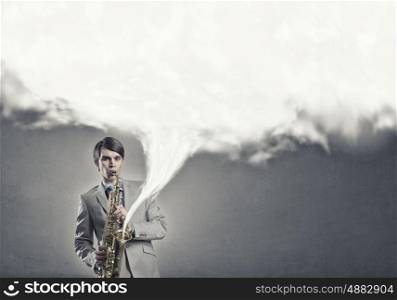 Handsome saxophonist. Young man playing saxophone and white cloud coming out