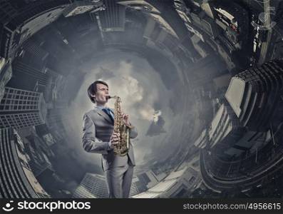 Handsome saxophonist. Young man playing saxophone on cityscape background