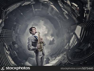 Handsome saxophonist. Young man playing saxophone on cityscape background