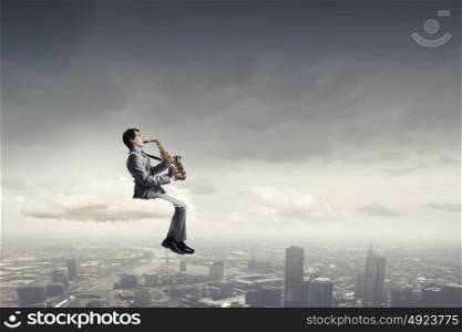 Handsome saxophonist. Young man sitting on cloud playing saxophone