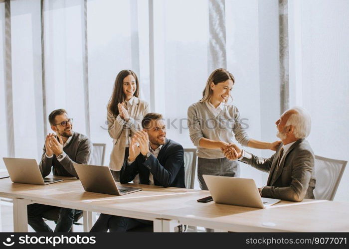 Handsome senior businessman working together with young business people in the office