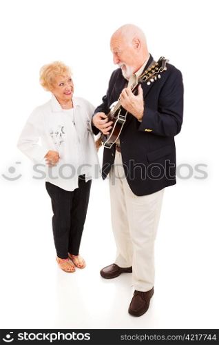 Handsome senior man serenading his beautiful lady on the mandolin. Full body isolated.