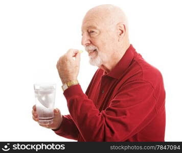 Handsome senior man stays healthy by taking a fish oil supplement with a glass of water. Isolated on white.