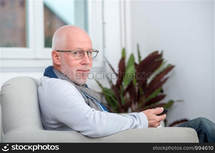 handsome senior man using a phone on the sofa
