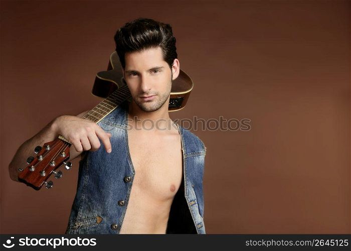 Handsome sexy young man musician guitar player portrait on brown