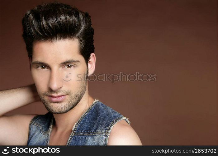 Handsome sexy young man portrait denim jacket brown background