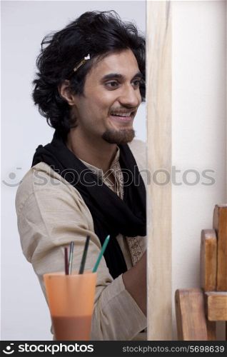 Handsome smiling artist painting