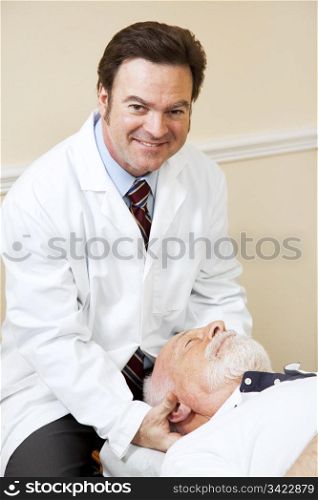 Handsome, smiling chiropractor adjusting a senior man&rsquo;s neck.