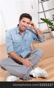 Handsome smiling man sitting on the floor
