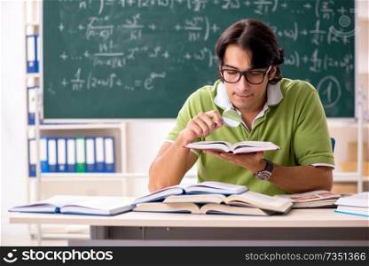 Handsome student in front of chalkboard with formulas 