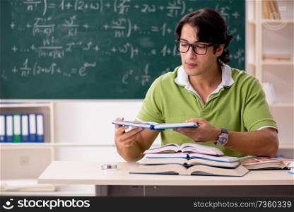 Handsome student in front of chalkboard with formulas 