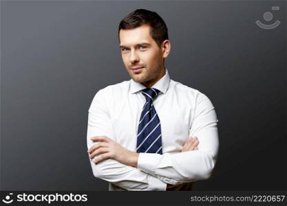 Handsome stylish caucasian businessman on grey background with copy space. Handsome stylish businessman on grey background