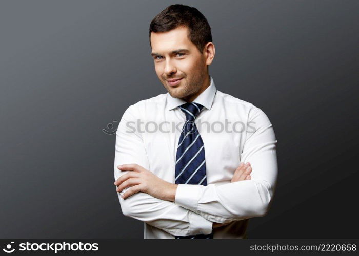 Handsome stylish caucasian businessman on grey background with copy space. Handsome stylish businessman on grey background