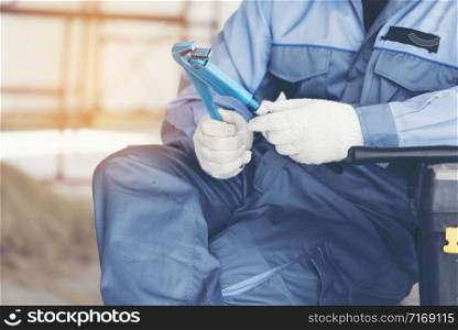 Handsome technician wear technical uniform suit holding wrench in hands. Engineering concept.
