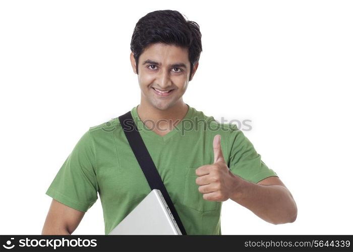 Handsome university student giving thumbs up over white background