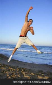 Handsome winner young man jumping on the blue beach