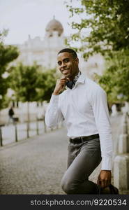 Handsome young African American businessman waitng a taxi on a street