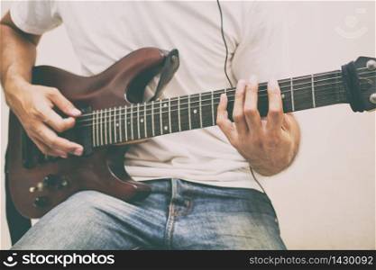 Handsome young asian men playing guitar and listen music with headphones,Blurry and soft focus