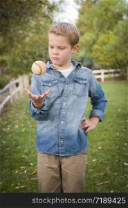 Handsome Young Boy Tossing Up His Baseball in the Park.