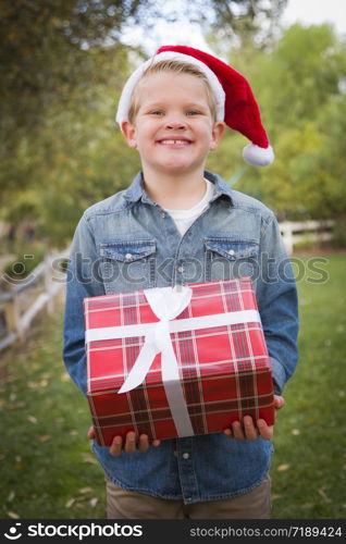 Handsome Young Boy Wearing Holiday Clothing Holding Christmas Gift Outside.