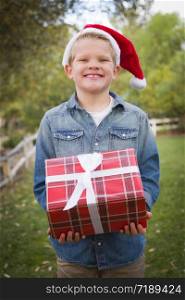 Handsome Young Boy Wearing Holiday Clothing Holding Christmas Gift Outside.