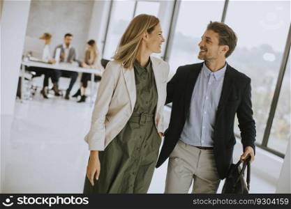 Handsome young business couple walking together at office space