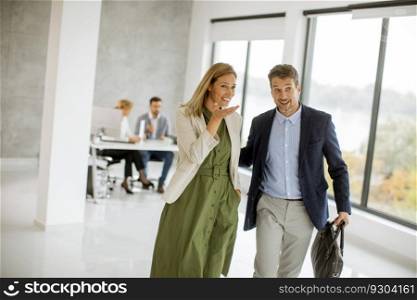 Handsome young business couple walking together at office space