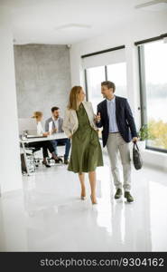 Handsome young business couple walking together at office space