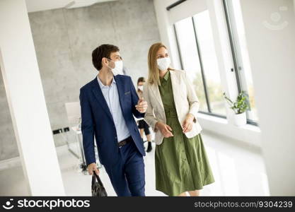 Handsome young business couple walking together while wear protective masks to prevent   corona viruus at office space