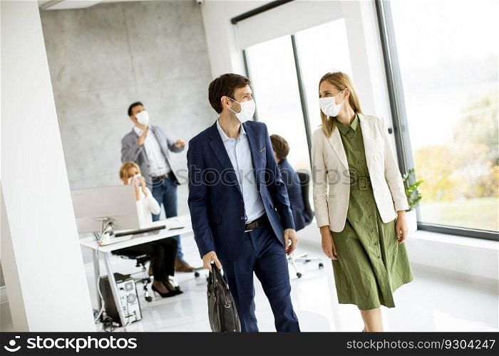 Handsome young business couple walking together while wear protective masks to prevent   corona viruus at office space