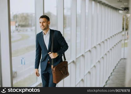 Handsome young business executive with briefcase going up the stairs