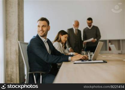 Handsome young business man using laptop computer in the office