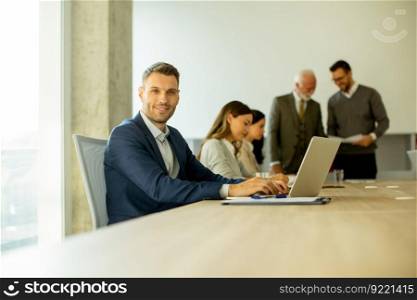 Handsome young business man using laptop computer in the office