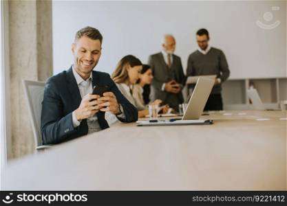 Handsome young business man using mobile phone in the office