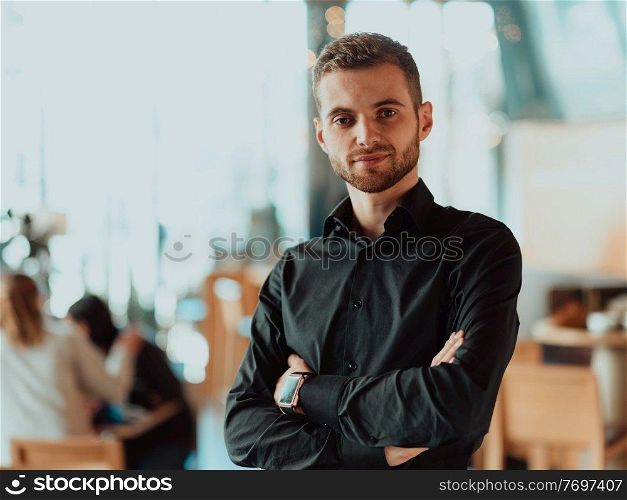 Handsome young businessman in the office. Cheerful self-confident professional man with crossed hands portrait. Business success concept. Cheerful self confident professional businessman with crossed hands portrait.