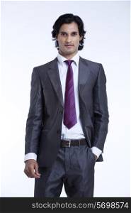 Handsome young businessman standing against white background