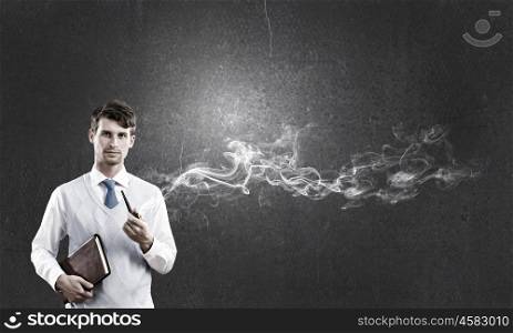 Handsome young businessman thinking over ideas and smoking pipe. Businessman and pipe smoke