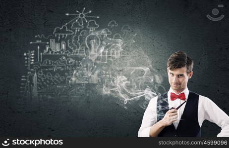 Handsome young businessman thinking over ideas and smoking pipe. Businessman and pipe smoke