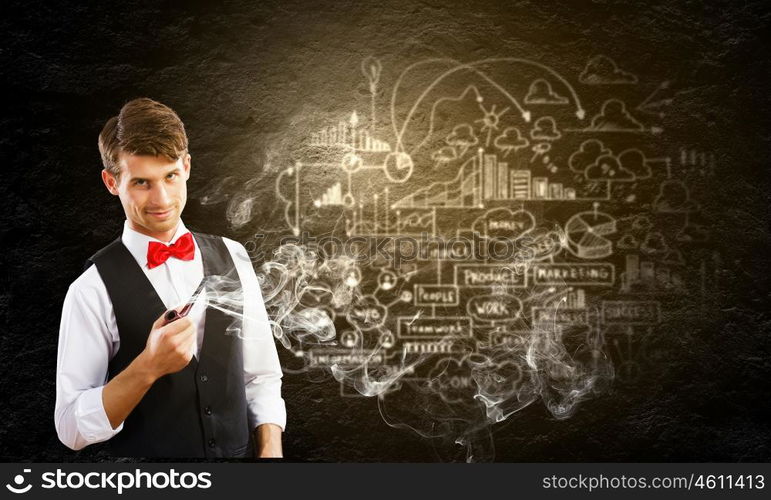 Handsome young businessman thinking over ideas and smoking pipe. Businessman and pipe smoke