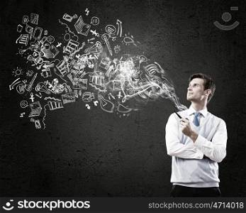 Handsome young businessman thinking over ideas and smoking pipe. Businessman and pipe smoke