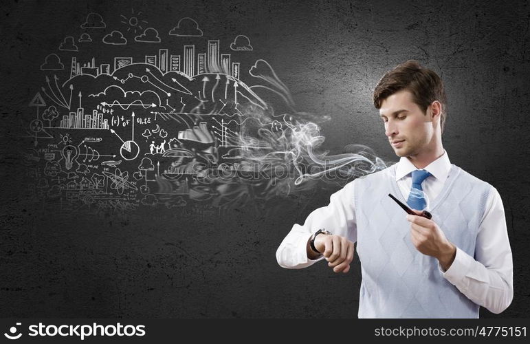 Handsome young businessman thinking over ideas and smoking pipe. Businessman and pipe smoke