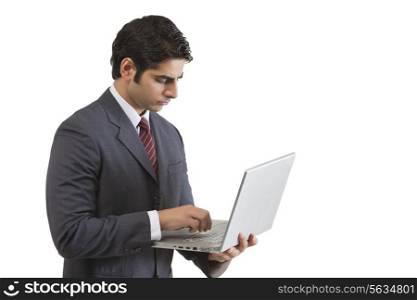 Handsome young businessman working on laptop