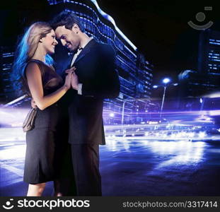 Handsome young couple dancing on the street and smiling