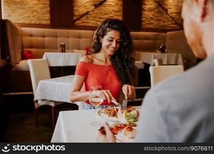 Handsome young couple having lunch with white wine in the restaurant