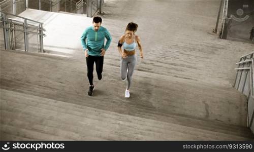 Handsome young couple running in the urban environment
