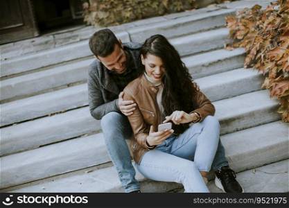 Handsome young couple sitting on outdoor stairs on a autumn day